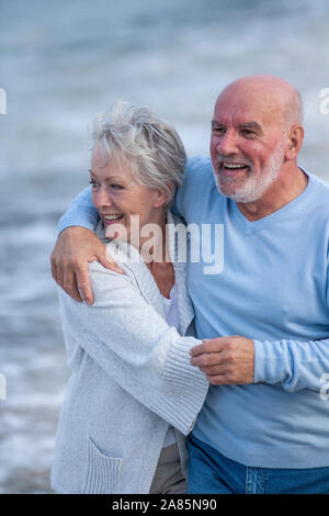 Senior couple walking along the shore Stock Photo