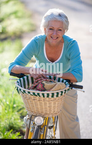 Senior woman cycling Stock Photo