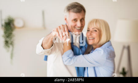 Senior couple moving into new home, man showing keys Stock Photo