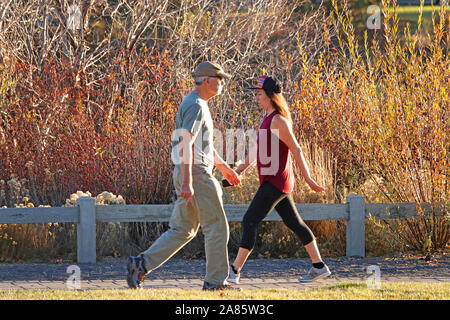 A man and 2oman walking in opposite directions along a river path on the Deschutes River in Bend, Oregon Stock Photo