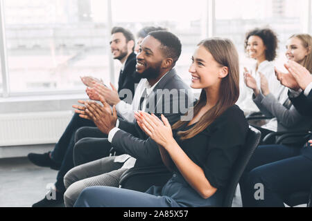 Diverse business team greeting speaker with applause Stock Photo