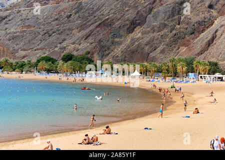 Tenerife, Spain - October 13, 2019: People sunbathing on sandy picturesque beach of Playa de Las Teresitas, Canary Islands, Tenerife, Spain Stock Photo