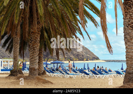 Tenerife, Spain - October 13, 2019: People sunbathing on sandy picturesque beach of Playa de Las Teresitas, Canary Islands, Spain Stock Photo