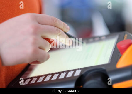 Hand with a pencil over an electronic   control panel for special equipment Stock Photo
