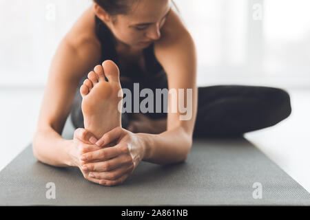 Fit woman warmup stretching, training indoors, focus on foot Stock Photo