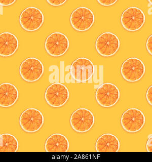 Seamless diagonal pattern of handmade dried orange slices on trendy yellow background. Creative diy christmas decorations flat lay background.  Square Stock Photo