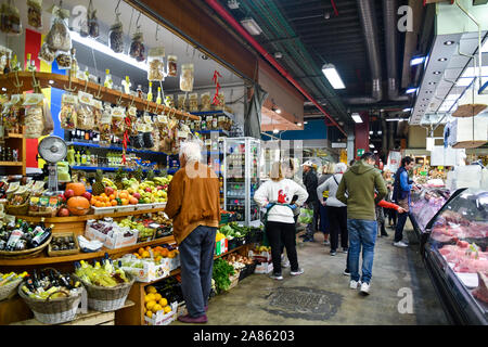 Central Market of San Lorenzo in the city center of Florence with customers buying fresh food at counters of grocery and butchery, Tuscany, Italy Stock Photo