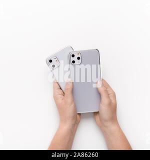 Customer holding Two new iPhones 11 with different cameras Stock Photo
