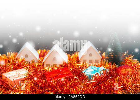 Christmas snowfall in small village. Christmas gift boxes. Stock Photo