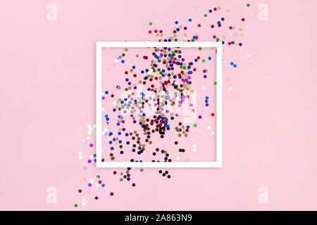 New Year Christmas top view flat lay. Colorful confetti with copy space on pink background Stock Photo