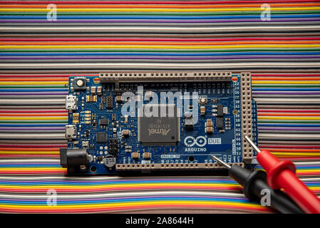 Arduino Due displayed on jumper wire background with meter probes. Stock Photo