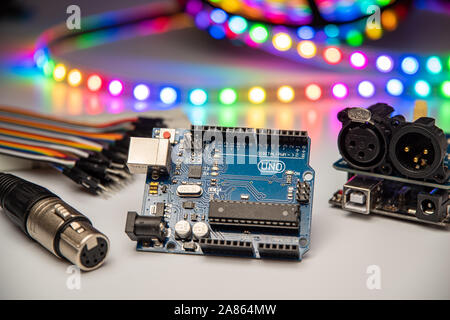 Arduino Uno displayed with DMX shield, XLR connector, jumper wires, and LED strip. Stock Photo