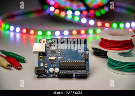 Arduino Uno displayed with LED strip, alligator clip leads, and hookup wire. Stock Photo