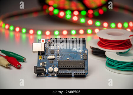 Arduino Uno displayed with LED strip, alligator clip leads, and hookup wire. Stock Photo