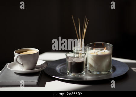 coffee, candles and aroma reed diffuser on table Stock Photo
