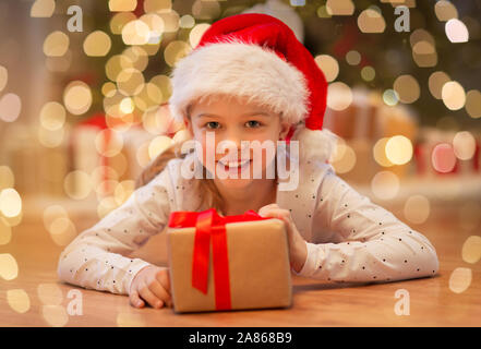 smiling girl in santa hat with christmas gift Stock Photo