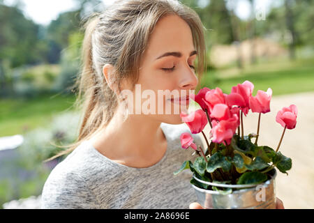 young woman with cyclamen flowers at summer garden Stock Photo