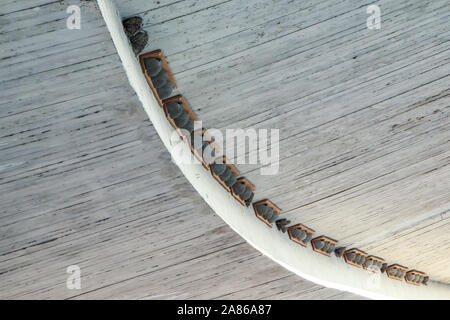 The artificial fake bird nests are hanging under the bridge on the concrete ceiling. Made to help the birds to have children fast. Stock Photo