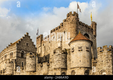 Fortified walls and towers of Gravensteen medieval castle with moat in the foreground, Ghent East Flanders, Belgium Stock Photo