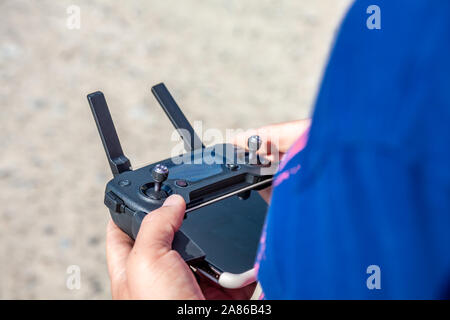 Man flying his drone by using a remote controller on the beach. Stock Photo