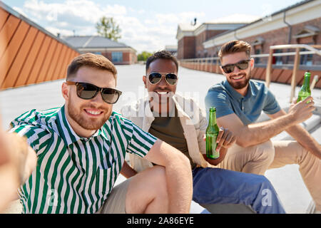 men drinking beer and taking selfie on street Stock Photo