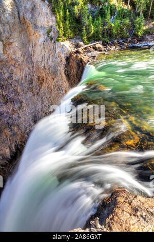 Brink of Lower Falls at Yellowstone National Park showing rushing waters from the Yellowstone River falling into the Grand Canyon of the Yellowstone. Stock Photo