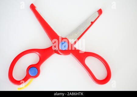 Red handle scissors placed on a white background - Image Stock Photo