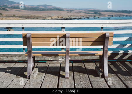 Empty bench on a wooden pier in Avila Beach, CA Stock Photo