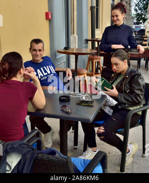 Customers at table in cafe being served by waitress in old town Pula, Croatia Stock Photo