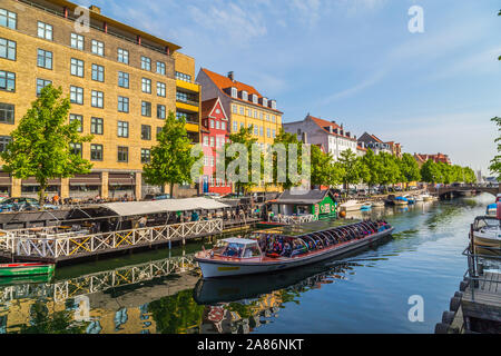 COPENHAGEN, DENMARK - 23RD MAY 2017: Buildings and boats along the Christianshavn Canal in Copenhagen. Lots of people can be seen on the boat. Stock Photo