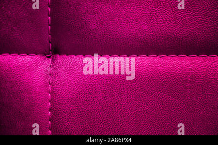 Bright electric pink textured artificial leather stitched with same color thread. Close-up of sofa surface. View from above. Highly detailed backgroun Stock Photo