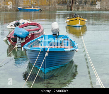 Boats in the enclosed safety of the harbour at Mousehole near Penzance on the south coast of Cornwall