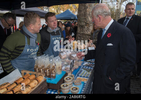 Prince Charles at the Swiss Cottage farmers market, meeting stall holders. Nick Ball and Jacob Sykes, who are free range chicken farmers from Fosse Meadows Farm, North Kilworth, Leicestershire. Its is the 20th anniversary of London Farmers Market. Prince Charles and the Duchess of Cornwall  paid a visit. 2019 to commemorate the event. 2010s HOMER SYKES Stock Photo