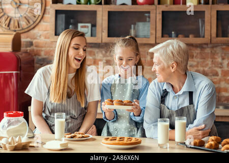 Emotional little girl holding plate with homemade cupcakes Stock Photo