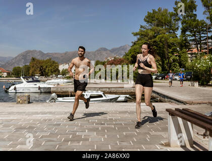 Dobrota, Montenegro, Sep 16, 2019: A couple jogging along the waterfront Stock Photo