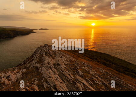 The setting sun over Cardigan Bay. Viewed from the top of Foel Y Mwnt, Ceredigion Stock Photo