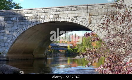 wide shot of the henniker covered bridge in new hampshire with trees in fall Stock Photo