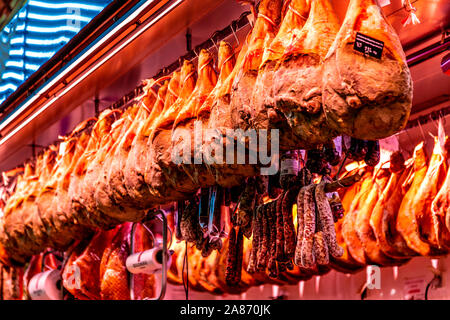 Cured iberian hams hanging above the butchers stall at Mercado Les Halles in Biarritz, France Stock Photo