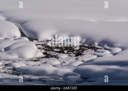 Close shot of a stream covered in snow. Kaunertal valley in Tyrol, in the Austrian Alps. Massive snow falls are covering this area in winter. Stock Photo