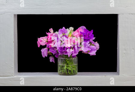 A bunch of sweet pea flowers framed black background Stock Photo