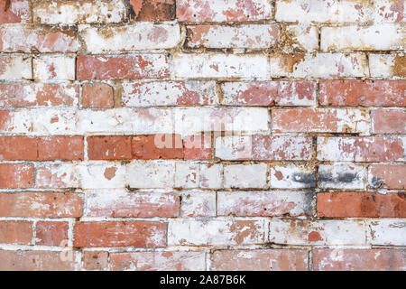 Solid rustic background of brick wall looks destroyed and has peeling old paint. Flat layer for mock up and template or card with text space. Stock Photo