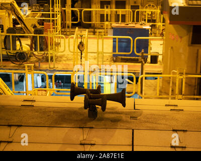 Close up of three horns on top of a yellow train locomotive housed in a repair facility. Stock Photo