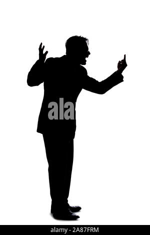 Silhouette of a backlit model posing as a businessman on a white background.  He is shouting in anger and is furious Stock Photo