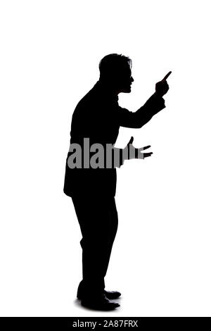 Silhouette of a backlit model posing as a businessman on a white background.  He is shouting in anger and is furious Stock Photo