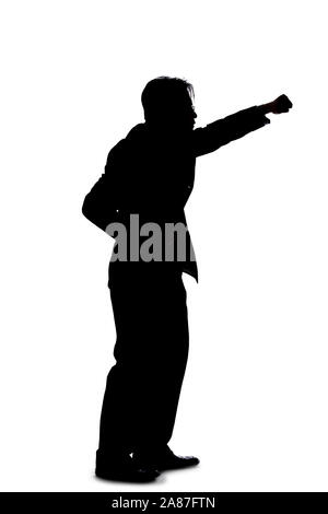 Silhouette of a backlit model posing as a businessman on a white background.  He is punching out of anger with his fists. Stock Photo