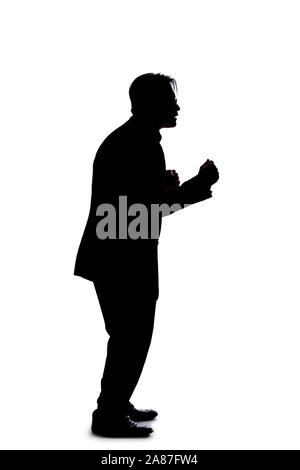 Silhouette of a backlit model posing as a businessman on a white background.  He is punching out of anger with his fists. Stock Photo