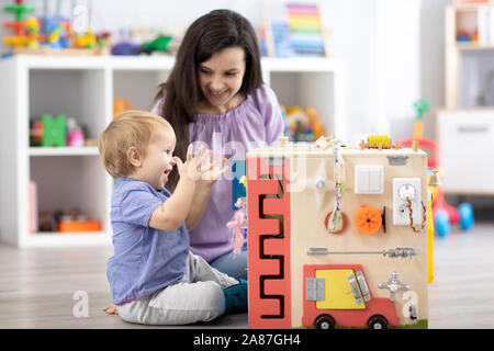 Child with teacher playing educational toys Kid toddler develops motor skills. Stock Photo