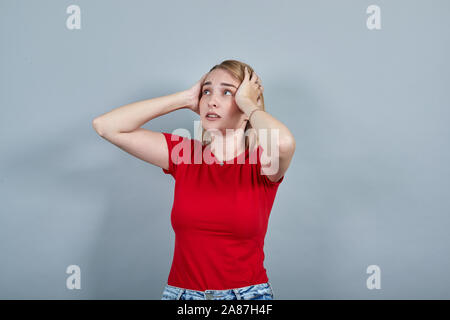 Portrait of shocked screaming young woman looking aside, putting hands Stock Photo