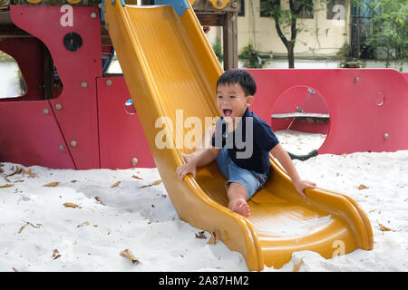 Child playing on outdoor playground. Kids play on school or kindergarten yard. Stock Photo