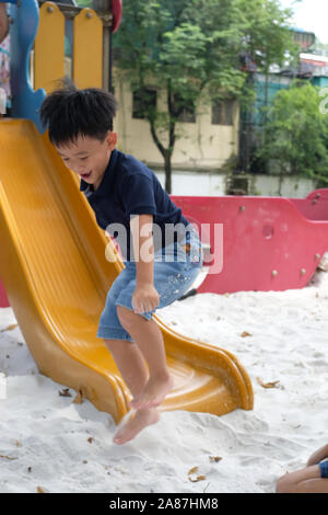 Child playing on outdoor playground. Blur image of a kid jumping Stock Photo
